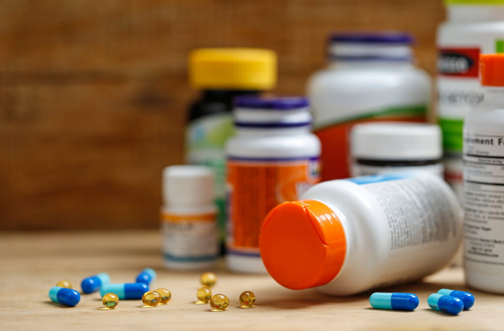 Medicine bottles and tablets on wooden desk Medication